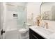 Stylish bathroom with white tile, bathtub with glass doors, black vanity, and modern fixtures at 3142 W 26Th Ave, Denver, CO 80211