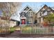 Charming two-story home with a red door, complemented by a brick walkway and white picket fence at 3142 W 26Th Ave, Denver, CO 80211