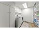 Bright laundry room featuring modern appliances, storage cabinets, and tile flooring at 24149 Shooting Star Dr, Golden, CO 80401