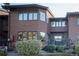 Townhome exterior featuring wood siding, updated windows, and a small deck at 5845 W Mansfield Ave # 259, Denver, CO 80235