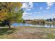 A tranquil lake view features autumn trees and a beautiful grassy area at 5845 W Mansfield Ave # 259, Denver, CO 80235