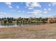 Community pond surrounded by lush trees and grass provides a serene atmosphere at 5845 W Mansfield Ave # 259, Denver, CO 80235