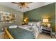 Bedroom with rustic bed frame, green walls, and two bedside tables with lamps at 32094 Christopher Ln, Conifer, CO 80433