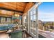 Elegant dining room with a wood table, green chairs, stylish lighting, and access to the outdoor deck at 32094 Christopher Ln, Conifer, CO 80433
