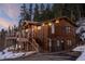 Inviting two-story home with wood siding, a deck, and a paved driveway, nestled in a serene natural setting at 32094 Christopher Ln, Conifer, CO 80433