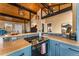 Modern kitchen with stainless steel appliances, stone backsplash, and breakfast bar at 32094 Christopher Ln, Conifer, CO 80433