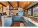 Well-appointed kitchen featuring blue cabinets, stone backsplash, modern appliances, and mountain views at 32094 Christopher Ln, Conifer, CO 80433