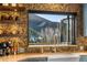Stunning kitchen sink featuring pebble backsplash, floating shelves, and a window view of the mountains at 32094 Christopher Ln, Conifer, CO 80433