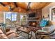 Inviting living room with a stone fireplace, wood ceiling, comfortable seating, and scenic views at 32094 Christopher Ln, Conifer, CO 80433