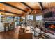 Cozy living room with a stone fireplace, wood ceiling, comfortable seating, and access to the deck at 32094 Christopher Ln, Conifer, CO 80433