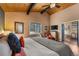 Inviting main bedroom with wood ceiling, window view, and ensuite bathroom access at 32094 Christopher Ln, Conifer, CO 80433