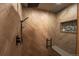 Walk-in shower featuring gray herringbone tile, rainfall showerhead, hand shower, and stone tiled shelf at 32094 Christopher Ln, Conifer, CO 80433