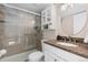 Updated bathroom features tile shower with glass door and granite-topped vanity with white cabinets at 3971 S Quintero Way, Aurora, CO 80013