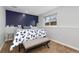 Bedroom with blue accent wall, window, and bench at 3971 S Quintero Way, Aurora, CO 80013