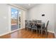 Cozy dining area with wood floors, a table for six, and sliding doors leading to an outdoor deck at 3971 S Quintero Way, Aurora, CO 80013