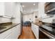 Galley kitchen featuring stainless appliances, granite counters, and white cabinetry in an open layout home at 3971 S Quintero Way, Aurora, CO 80013