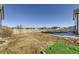 Large backyard with a white picket fence surrounding the perimeter on a sunny day at 16650 Shadow Wood Ct, Hudson, CO 80642