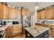 Well-equipped kitchen with granite countertops, stainless steel appliances, and custom cabinetry at 16650 Shadow Wood Ct, Hudson, CO 80642