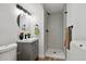 Modern bathroom with a stylish shower and black fixtures, alongside vanity and lights at 9366 Clermont Dr, Thornton, CO 80229
