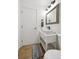 Cozy bathroom with a pedestal sink, decorative mirror, and modern finishes at 9366 Clermont Dr, Thornton, CO 80229