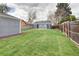 Grassy backyard features a detached structure, wooden fence, and mature trees at 3320 N Madison St, Denver, CO 80205