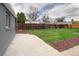 Grassy backyard features a concrete slab, wooden fence, and freshly laid mulch at 3320 N Madison St, Denver, CO 80205