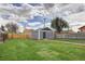Expansive backyard showing a gray detached garage and a grassy lawn enclosed by wooden fencing at 3320 N Madison St, Denver, CO 80205