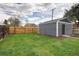 Spacious backyard boasts detached structure with wooden fence and grass lawn at 3320 N Madison St, Denver, CO 80205