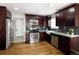 Updated kitchen featuring dark wood cabinetry, stainless steel appliances, and granite countertops at 3320 N Madison St, Denver, CO 80205