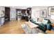Open-concept living space featuring hardwood floors, modern kitchen, and stylish green sofa at 3320 N Madison St, Denver, CO 80205