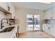 Modern kitchen with white cabinets, stainless steel appliances and sliding door to yard at 994 S Vivian Ct, Lakewood, CO 80228