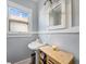 Clean bathroom with pedestal sink, light gray walls, and wooden cabinet at 3412 Zuni St, Denver, CO 80211