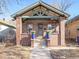 Brick home with a classic front porch and landscaping at 3412 Zuni St, Denver, CO 80211