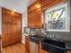 Well-equipped kitchen with wood cabinets, black countertops, and stainless steel appliances at 3412 Zuni St, Denver, CO 80211