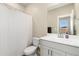 Neutral toned bathroom with a sink vanity, toilet, and shower with white curtain at 6150 Sugarloaf St, Brighton, CO 80601
