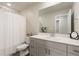 Well-lit bathroom with a shower featuring a white curtain, vanity, and a spacious mirror at 6150 Sugarloaf St, Brighton, CO 80601
