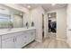 Modern bathroom featuring double sinks, white cabinets, and a walk-in closet at 6150 Sugarloaf St, Brighton, CO 80601