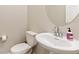 Powder room featuring a pedestal sink, updated fixtures, and a modern round mirror at 6150 Sugarloaf St, Brighton, CO 80601