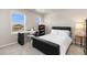 Bedroom featuring a black bed frame, study desk, large windows, and neutral walls at 6150 Sugarloaf St, Brighton, CO 80601