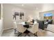 Cozy dining area with a round table and white chairs, filled with natural light at 6150 Sugarloaf St, Brighton, CO 80601
