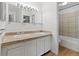 Bright bathroom featuring double sinks, large mirror and bathtub with tiled walls at 9050 Zephyr Ct, Broomfield, CO 80021