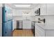 Bright kitchen featuring white cabinets, marble countertops, stainless steel appliances, and wood-look flooring at 9050 Zephyr Ct, Broomfield, CO 80021