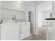 Bright laundry room with washer, dryer and shelves at 9050 Zephyr Ct, Broomfield, CO 80021