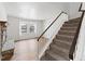 Staircase with neutral carpet, wood trim, and a stone fireplace beneath a window at 9050 Zephyr Ct, Broomfield, CO 80021