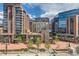 Exterior of multiple brick buildings with glass accents with outside seating and brick and tree landscaping at 1735 19Th St # 5B, Denver, CO 80202