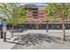 View of a brick building with trees in the foreground and an outdoor seating area for dining at 1735 19Th St # 5B, Denver, CO 80202