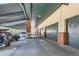 Covered parking area in building with multiple parking garages, brick columns, and parked vehicles at 1735 19Th St # 5B, Denver, CO 80202