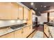 Modern kitchen featuring stainless steel appliances, light wood cabinets, and granite countertops at 1735 19Th St # 5B, Denver, CO 80202