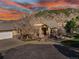 Stunning home with beautiful stone and wood accents, set against a mountain backdrop and colorful sunset sky at 501 Young Cir, Castle Rock, CO 80104