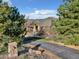 Inviting front exterior featuring stone accents, mature trees, and a paved driveway at 501 Young Cir, Castle Rock, CO 80104